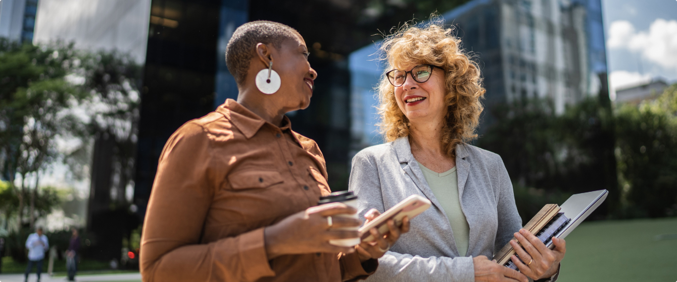 Two business woman talking and walking.