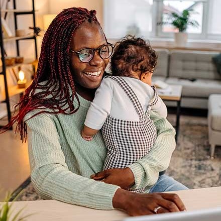 Mom and child using laptop at home.