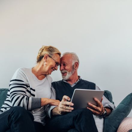 older couple with tablet smiling