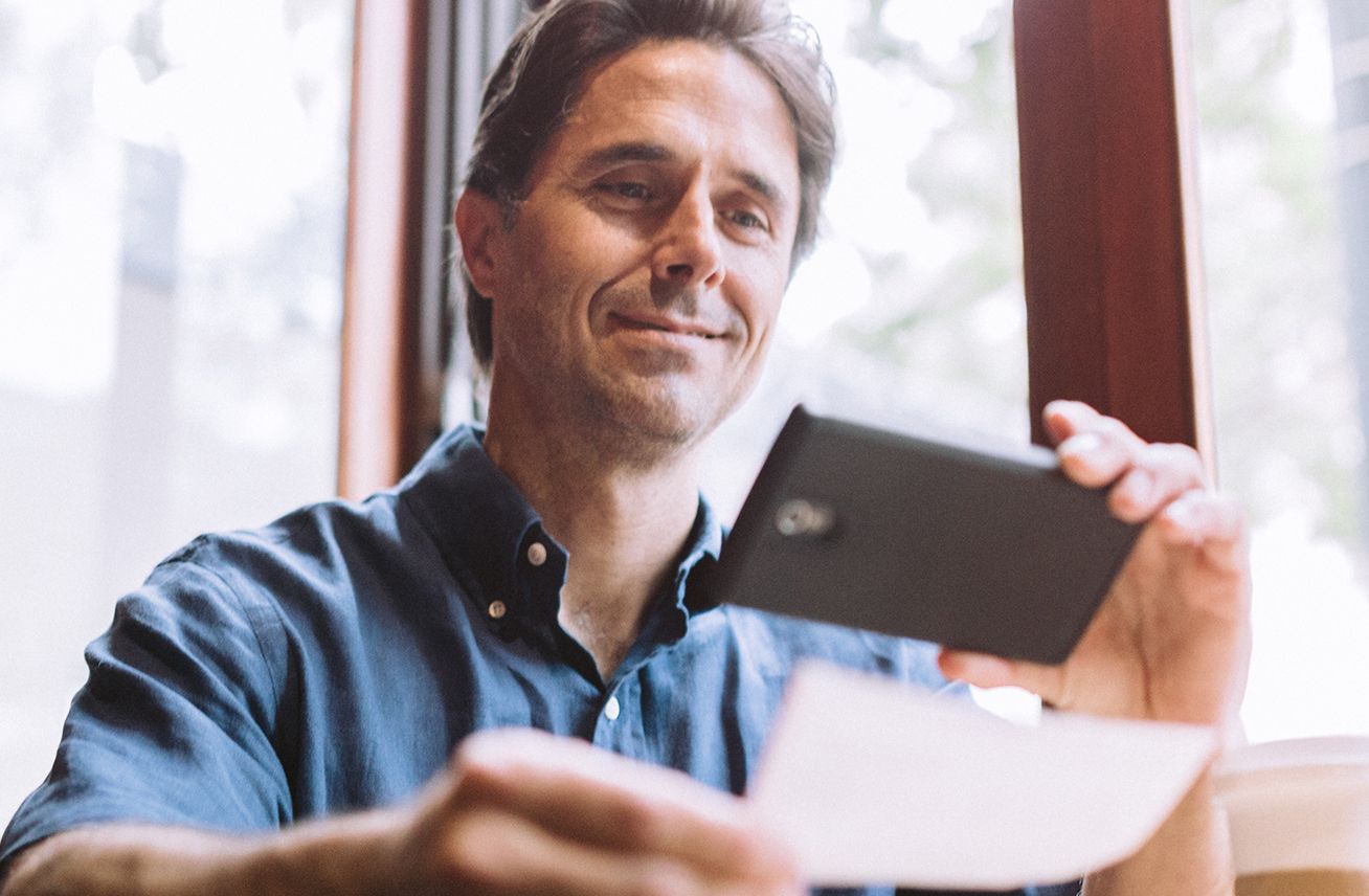 man smiling looking at mobile device