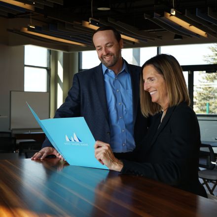 business man and woman holding west shore folder