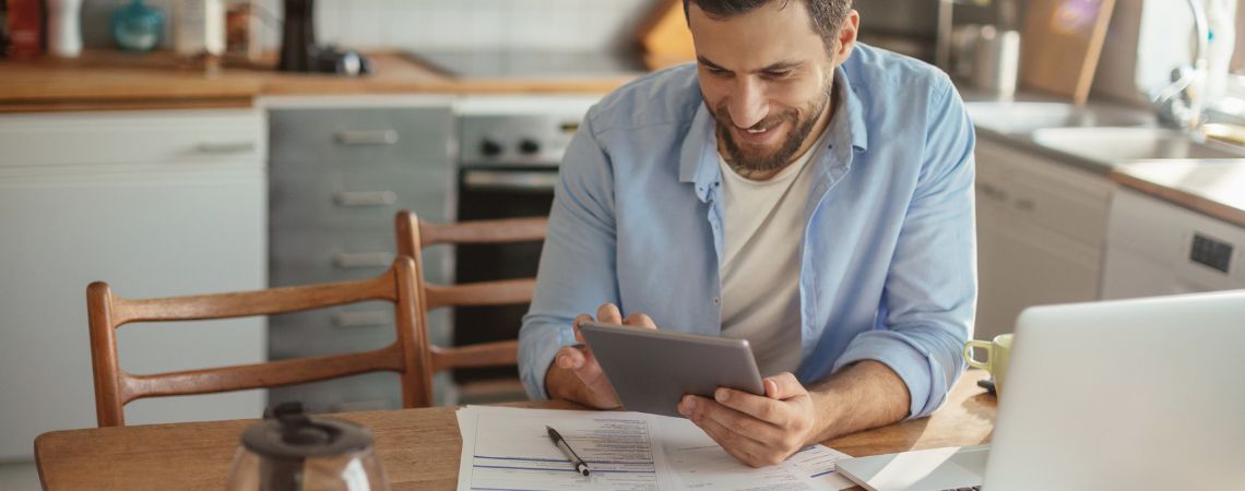 man at laptop holding tablet