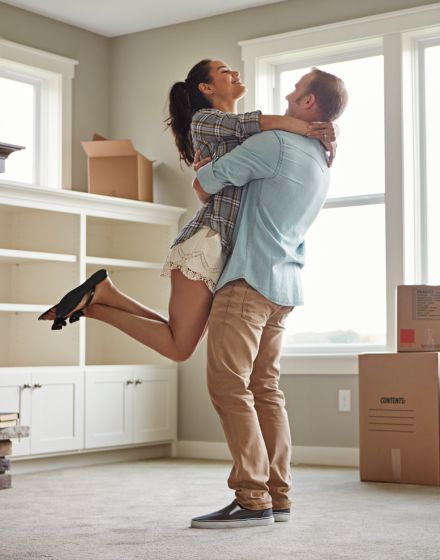 couple hugging in empty living room