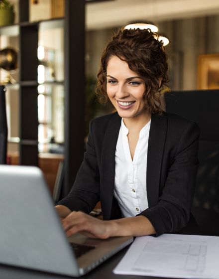 woman in a suit looking at a computer