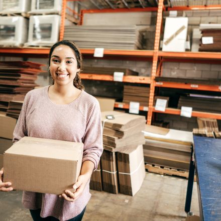 woman holding box in warehouse